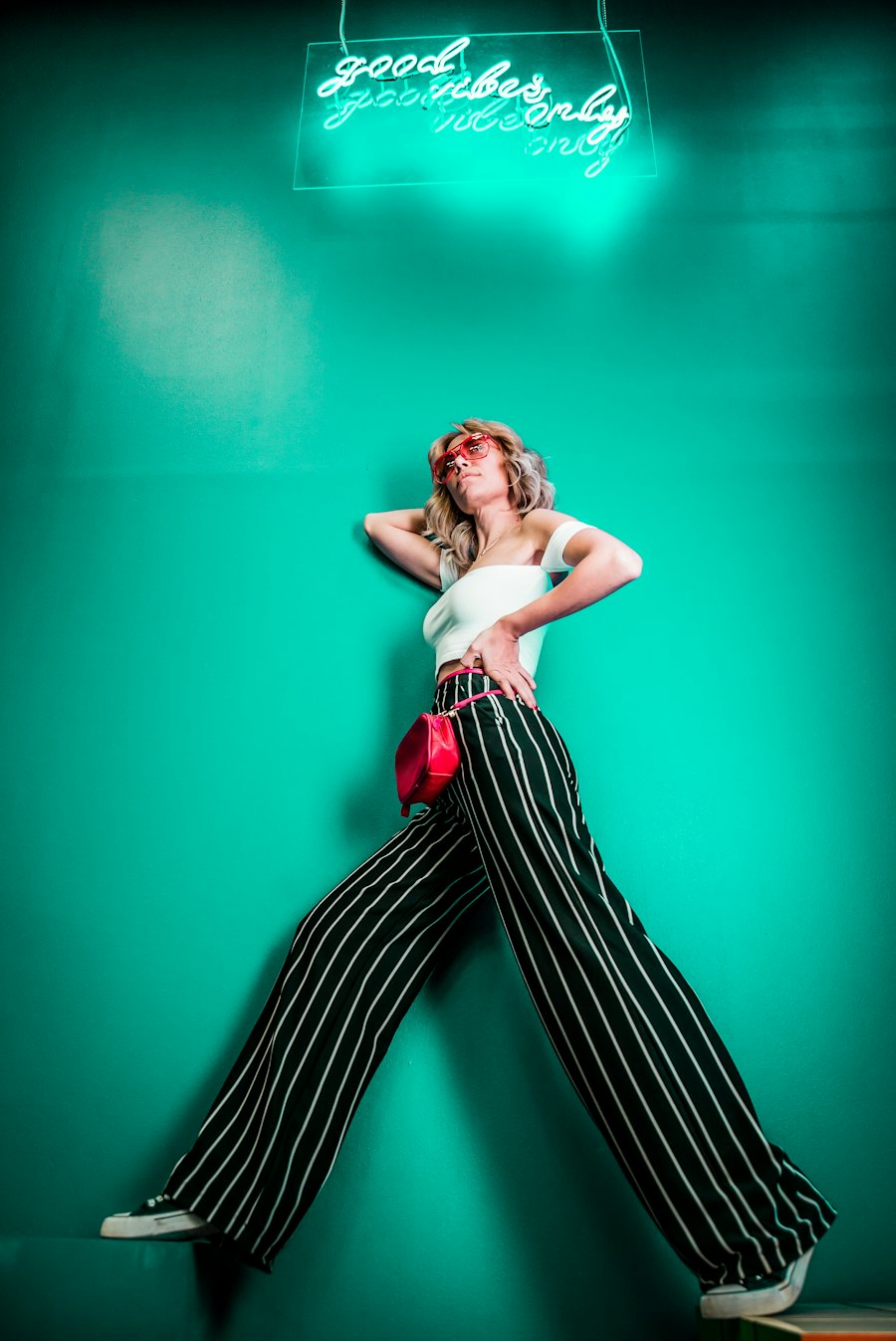Striped wide-leg pants under a neon light